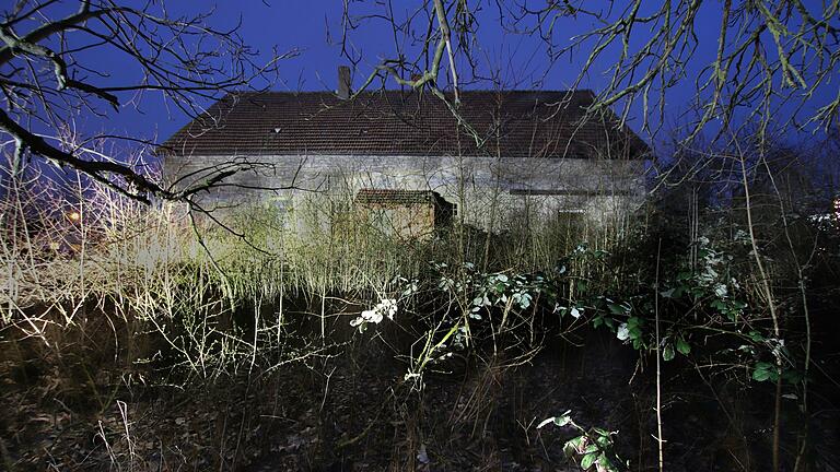 Ein Haus, in dem es spukt? Das alte Natursteingebäude am Kitzinger Ortsrand wirkt in der Dämmerung noch etwas unheimlicher.