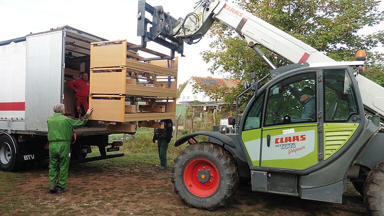 Millimeterarbeit - Reinhard Schmitt mit dem Teleskoplader, Albin Kopp als Einweiser und Teni Čuček auf der Ladefläche des Lkw, im Hintergrund Edgar Hauck.