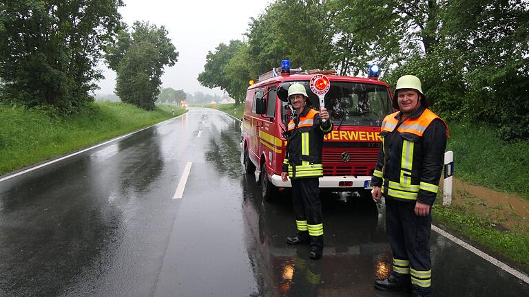 Auch auf der Staatsstraße zwischen Römershofen und Rügheim wälzte sich das Wasser (im Hintergrund) über die Fahrbahn. Die Feuerwehr Rügheim sicherte die Einsatzstelle ab.