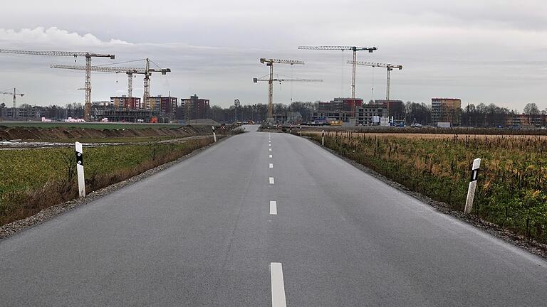 Eine leere Straße führt zu einer Großbaustelle mit vielen Kränen. Mit einer Flächensparoffensive will die Landesregierung dem Flächenverbrauch entgegenwirken. Eine leere Straße führt zu einer Großbaustelle mit vielen Kränen. Mit einer Flächensparoffensive will die Landesregierung dem Flächenverbrauch entgegenwirken. 