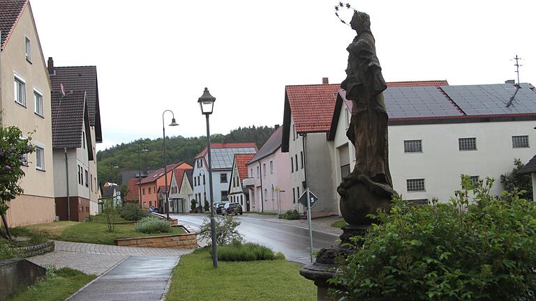 Blick vom alten Rathaus von Stettfeld in die Hauptstraße: Zu sehen sind im Vordergrund die Marienstatue und entlang der Straße Straßenlampen, für die nun ein Nachtrag zum Straßenbeleuchtungsvertrag akzeptiert wurde.
