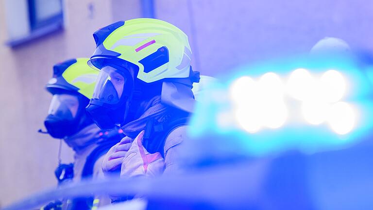 Feuerwehr       -  Feuerwehrleute stehen an einem Einsatzort.