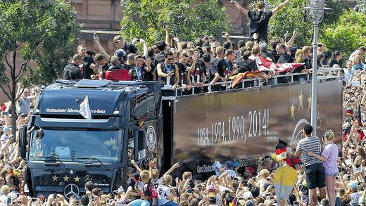 Loveparade für die Weltmeister: Hunderttausende feiern die Brasilien-Heimkehrer bei ihrer Ankunft in Berlin schon auf dem Weg zur Fanmeile.