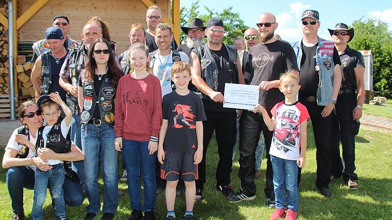 Wolfgang Wende vom Trikerstammtisch Unterfranken (Vierter von rechts) überreicht einen Spendenscheck über 333, 33 Euro an Sebastian Zimmer von der Universitäts-Kinderklinik.