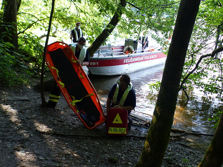 Ein Boot der Feuerwehr bereitet mit der Besatzung auf die Bergung eines Verletzten vor.