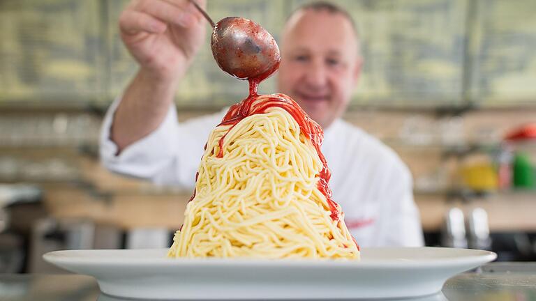 Vanilleeis mit einem Kern aus Sahne, Erdbeersoße drüber und weiße Schokostreusel – fertig ist der Klassiker.