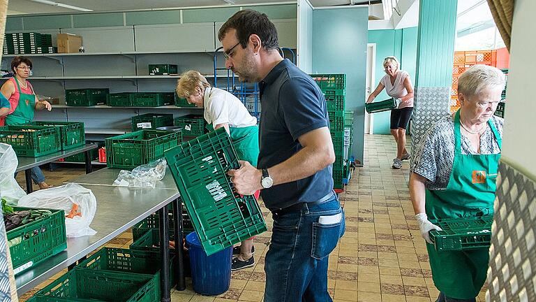 Bevor die Lebensmittel ausgegeben werden, werden sie noch sortiert und in die grünen Kisten gepackt. Bevor die Lebensmittel ausgegeben werden, werden sie noch sortiert und in die grünen Kisten gepackt.