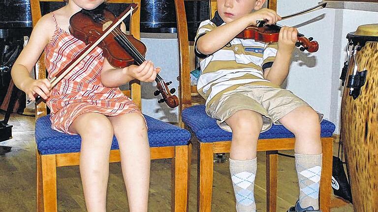 Hoch konzentriert: Es kann schon einmal sein, dass beim Unterricht mit den Beinen geschaukelt wird, denn die Beine erreichen noch nicht den Boden. Doch das ist egal, denn die Lucie und Joseph finden Geigenspielen toll und sind mit Eifer bei der Sache.