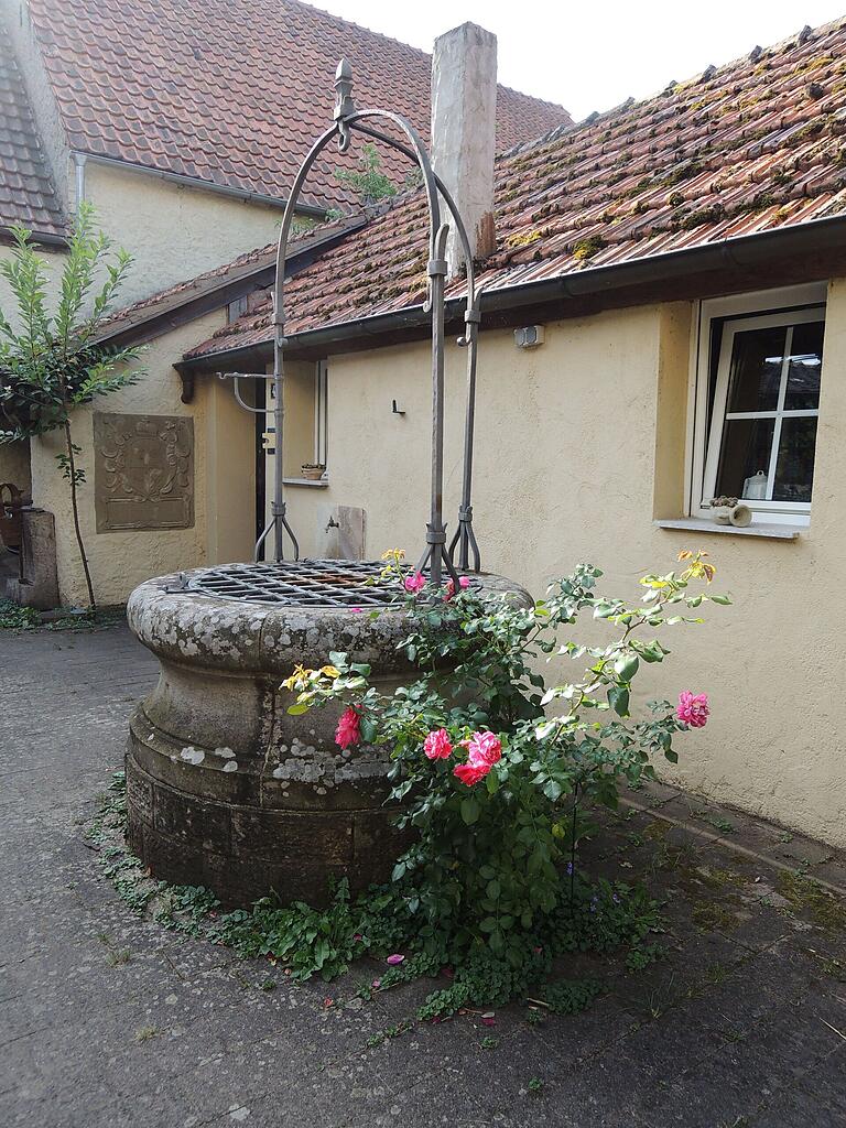 Rosen setzen Farbakzente am Brunnentrog im Hof. Rosen setzen Farbakzente am Brunnentrog im Hof.