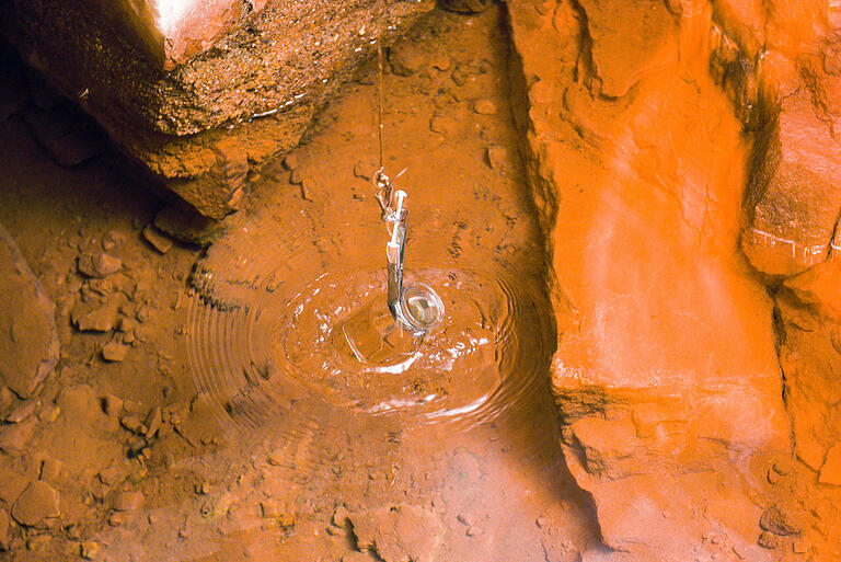 Symbolfoto: Aus einer begehbaren Quelle bei Lohr am Main (Lkr. Main-Spessart) wird mit einem sterilen Glasbehälter eine Wasserprobe gezogen. Symbolfoto: Aus einer begehbaren Quelle bei Lohr am Main (Lkr. Main-Spessart) wird mit einem sterilen Glasbehälter eine Wasserprobe gezogen.
