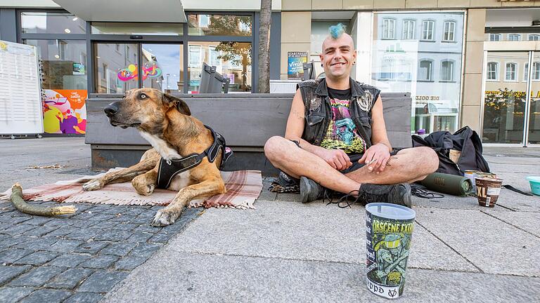 Vor knapp zehn Jahren hat sich Smiley dazu entschieden, auf der Straße zu leben. Seitdem ist er viel herumgekommen. Inzwischen ist sein Stammplatz zum 'Schnorren' in der Spitalstraße in der Schweinfurter Innenstadt. Dort sitzt er beinahe jeden Tag mit seinem Hund Machete.