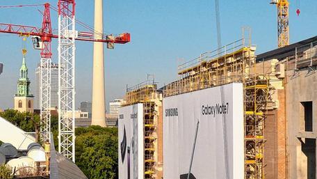 Noch arbeiten die Kräne. Gerüste mit Werbung verdecken die kunstvoll gestalteten Fassaden, aber bald fallen die Hüllen.