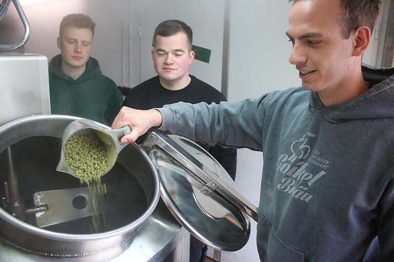 Handwerklicher Braubetrieb: Johannes Marschall füllt Hopfenpellets in den Sudkessel. Veit Pfeuffer-Martin und Jerome Wappes (links) beobachten den Schritt. Handwerklicher Braubetrieb: Johannes Marschall füllt Hopfenpellets in den Sudkessel. Veit Pfeuffer-Martin und Jerome Wappes (links) beobachten den Schritt.