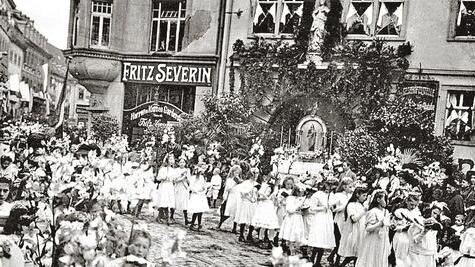 Aus den Anfängen: Die Fronleichnamsprozession zieht 1917 am Geschäft von Fritz Severin Anfang der Sanderstraße vorbei.