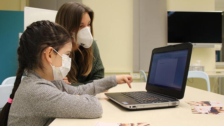 Katinka Desprez vom SONIA-Team zeigt Aischat M. wie man auf einem Laptop schreiben kann. Katinka Desprez vom SONIA-Team zeigt Aischat M. wie man auf einem Laptop schreiben kann.