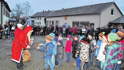Auf der Suche nach dem Christbaum - (gk) Alle Jahre wieder begeben sich die Kinder bei der Oberickelsheimer Dorfweihnacht auf die Suche nach dem geschmückten Weihnachtsbaum im Ort, der jedes Jahr in einem anderen Hof steht. Der Kinderchor unter der Leitung von Heidi Gebhardt stimmte am Kirchplatz die vielen großen und kleinen Besucher mit einem Lied schon einmal richtig ein, bevor die Vorsitzende des Gesangvereins, Renate Kraft, die Kinder auf die Suche schickte. Während im vergangenen Jahr der Baum sehr nah am Kirchplatz zu finden war, drehten die Kinder, gefolgt von den Erwachsenen, heuer erst einmal eine Runde über den Ostring, bevor es über die Untergasse in Richtung Bundesstraße 13 ging. Dann war es leicht, denn genau gegenüber der Einmündung sahen die Kinder schon den Baum im Hof der Familie Ingrid und Karl Finkenberger leuchten. Natürlich hatten die Kinder im Vorfeld eifrig geprobt, um mit vielen Liedern die Zuhörer zusammen mit den Mitgliedern des Bläserchors Frank Hümmer, Yanik Lilli, Jürgen Großmann, Leon Deutschmann, Katja Münz, Christine Kempf, Ralf Lilli und Renate Kraft auf Weihnachten einzustimmen. Selbstverständlich schaute auch der Nikolaus vorbei und bescherte die Kleinen. Auf der Suche nach dem Christbaum - (gk) Alle Jahre wieder begeben sich die Kinder bei der Oberickelsheimer Dorfweihnacht auf die Suche nach dem geschmückten Weihnachtsbaum im Ort, der jedes Jahr in einem anderen Hof steht. Der Kinderchor unter der Leitung von Heidi Gebhardt stimmte am Kirchplatz die vielen großen und kleinen Besucher mit einem Lied schon einmal richtig ein, bevor die Vorsitzende des Gesangvereins, Renate Kraft, die Kinder auf die Suche schickte. Während im vergangenen Jahr der Baum sehr nah am Kirchplatz zu finden war, drehten die Kinder, gefolgt von den Erwachsenen, heuer erst einmal eine Runde über den Ostring, bevor es über die Untergasse in Richtung Bundesstraße 13 ging. Dann war es leicht, denn genau gegenüber der Einmündung sahen die Kinder schon den Baum im Hof der Familie Ingrid und Karl Finkenberger leuchten. Natürlich hatten die Kinder im Vorfeld eifrig geprobt, um mit vielen Liedern die Zuhörer zusammen mit den Mitgliedern des Bläserchors Frank Hümmer, Yanik Lilli, Jürgen Großmann, Leon Deutschmann, Katja Münz, Christine Kempf, Ralf Lilli und Renate Kraft auf Weihnachten einzustimmen. Selbstverständlich schaute auch der Nikolaus vorbei und bescherte die Kleinen.