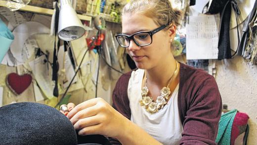 Feinarbeit: Elena Hupp an ihrem neuen Ausbildungsplatz in Würzburg, wo sie Bänder, Putz und Krempe nach Wünschen der Kundschaft gestaltet. Feinarbeit: Elena Hupp an ihrem neuen Ausbildungsplatz in Würzburg, wo sie Bänder, Putz und Krempe nach Wünschen der Kundschaft gestaltet.