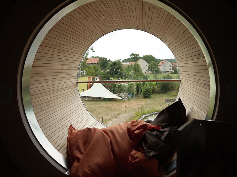 Beliebter Platz im UFO47: Das Bullauge mit Blick auf den Garten, in dem unter anderem eine Sauna und ein Teich beheimatet sind, und einige Köslauer Häuser. Beliebter Platz im UFO47: Das Bullauge mit Blick auf den Garten, in dem unter anderem eine Sauna und ein Teich beheimatet sind, und einige Köslauer Häuser.