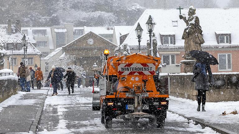 Ein Räumfahrzeug befreit die alten Mainbrücke in Würzburg von Schnee und Eis. In den Regionen Würzburg und Kitzingen ist am Mittwoch die Schule ausgefallen und auf den Straßen gab es zahlreiche Unfälle.