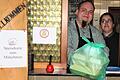 Mirko und Katharina Hauptig vom Gasthaus 'Schlappn' in Gerolzhofen reichen das typische Essen-zum-Mitnehmen-Paket durch das Fenster am Eingang ihrer Gaststätte.