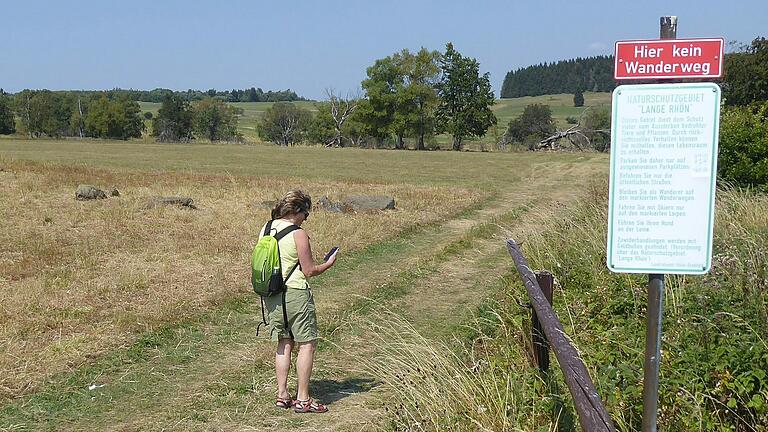 Eine Touristin orientiert sich am Handy, statt auf die Beschilderung im Naturschutzgebiet zu achten. Dass es keine entsprechenden Vorschläge im Internet gibt, ist Aufgabe des Digital-Rangers. Eine Touristin orientiert sich am Handy, statt auf die Beschilderung im Naturschutzgebiet zu achten. Dass es keine entsprechenden Vorschläge im Internet gibt, ist Aufgabe des Digital-Rangers.