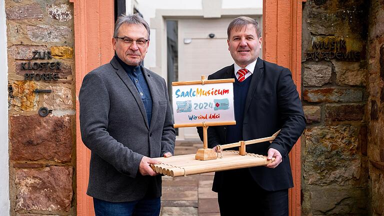 Das Bild zeigt den Bereichscenterleiter der Sparkasse Hammelburg, Matthias Warmuth (rechts), und den Künstlerischen Leiter der Bayerischen Musikakademie Hammelburg Kuno Holzheimer (links) bei der symbolischen Floßübergabe zur 2000 Euro Spende der ...       -  Das Bild zeigt den Bereichscenterleiter der Sparkasse Hammelburg, Matthias Warmuth (rechts), und den Künstlerischen Leiter der Bayerischen Musikakademie Hammelburg Kuno Holzheimer (links) bei der symbolischen Floßübergabe zur 2000 Euro Spende der Bank.