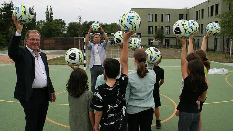 Ein Hoch auf König Fußball: Bezirkstagspräsident Erwin Dotzel (links) spendierte den Schülerinnen und Schülern der Dr.-Karl-Kroiß-Schule ein Dutzend fair produzierte und fair gehandelt Fußbälle. Die sorgten auch bei Schuldirektor Michael Schneider (Mitte) für Begeisterung.