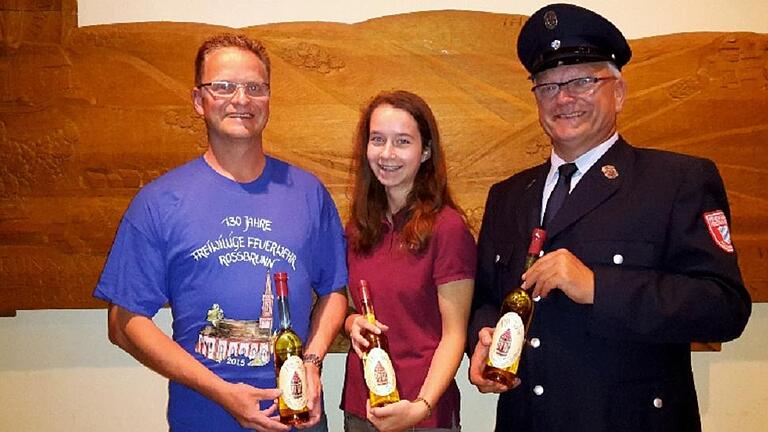 Gastgeschenk: Rainer Förster (links), Vorsitzender der Freiwilligen Feuerwehr Roßbrunn, bei der Präsentation der Schnapsidee zum Jubiläumsfest, einem 43-prozentigen Schnaps, durch Ehrendame Melanie Fuchs und Brauer Volker Horn.