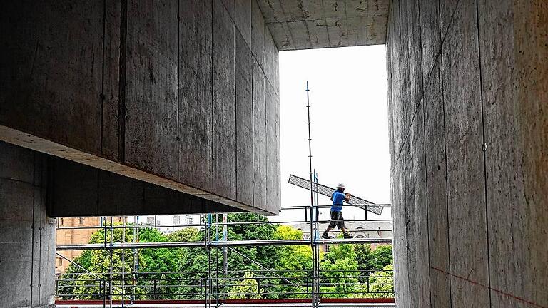 Neubau Kunsthalle Mannheim - Umstrittener Neubau: Ein Bauarbeiter am Rohbau der neuen Kunsthalle Mannheim, direikt in der Innenstadt nahe dem Wahrzeichen der Stadt, dem Wasserturm. Neubau Kunsthalle Mannheim - Umstrittener Neubau: Ein Bauarbeiter am Rohbau der neuen Kunsthalle Mannheim, direikt in der Innenstadt nahe dem Wahrzeichen der Stadt, dem Wasserturm.