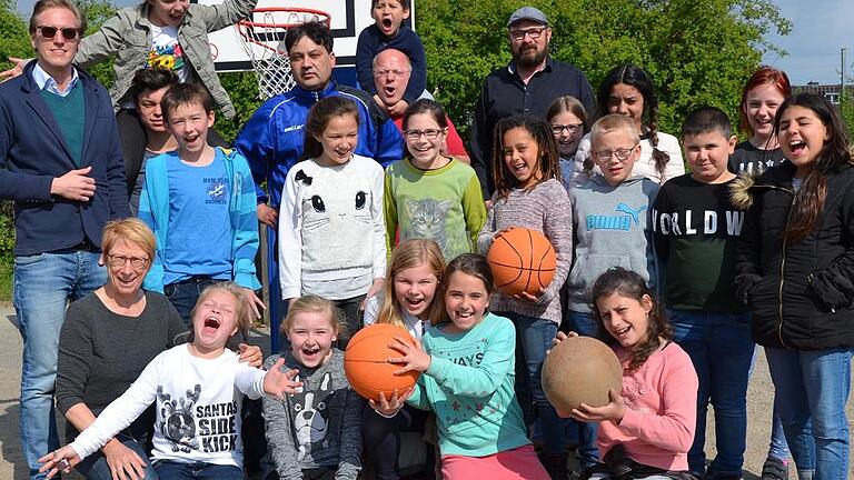 Die Kinder und ihre Betreuer vom Kinderzentrum &bdquo;Spieli&ldquo; in der Zellerau freuen sich sehr, dass sie dank des &bdquo;Projekts Würzburg&ldquo; auf dem Sportplatz nun auch Basketball spielen können. Im Bild (links außen) Max Schmitt sowie Vereinsvorsitzender Steffen Preuß (letzte Reihe rechts).