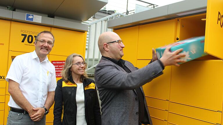 Der Selbstversuch an der neuen Poststation hat funktioniert. Bürgermeister Tobias Seufert (rechts) hat das Bücherpaket für den Kindergarten unter Anleitung von Gabriele Schulz aufgegeben. Links: Vertriebsmanager Christian Barthel.