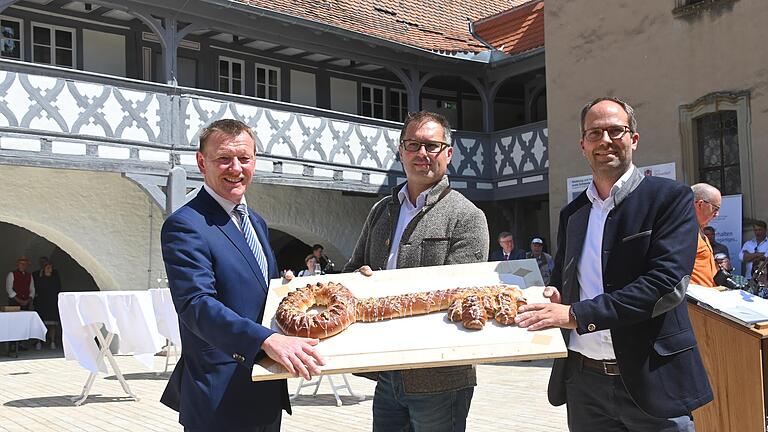 Den symbolischen Schlüssel bekam Bürgermeister Peter Juks (von links) bei Einweihung des Ochsenfurter Spitals&nbsp; von Architekt Tino Wagner und Landschaftsplaner Marcus Viebahn in Form eines Hefekuchens überreicht.