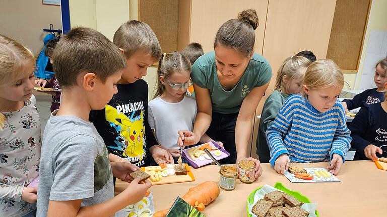 Svenja Arbes, Projektmanagerin der Öko-Modellregion Rhön-Grabfeld, mit teilnehmenden Schülerinnen und Schüler am Frühstücksbuffet. ( Svenja Arbes, Projektmanagerin der Öko-Modellregion Rhön-Grabfeld, mit teilnehmenden Schülerinnen und Schüler am Frühstücksbuffet. (