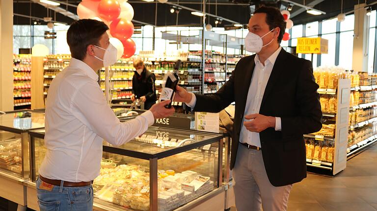 Bürgermeister Mario Paul (rechts) überreichte Rewe-Marktleiter Patrick Wartha eine Flasche 'Regent vom Beilstein' aus dem Weinberg des Bundes Naturschutz Lohr.&nbsp;