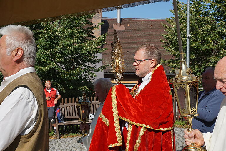 Domkapitular Jürgen Vorndran kam die Ehre zuteil, das Allerheiligste bei der Prozession zur Kreuzerhöhung um die Klosterkirche am Kreuzberg zu tragen.