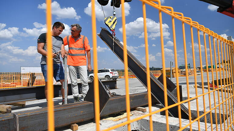 Losbauführer Wolfgang Thaler (rechts) mit einem Mitarbeiter. Rechts im Bild einer der Träger, die zur Verstärkung beim ablassen der Brückenelemente eingeschweißt werden. Foto: Daniel Peter