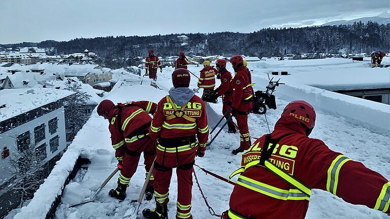 Ehrenamtliche der Deutschen Lebens-Rettungs-Gesellschaft (DLRG) waren im Landkreis Traunstein im Einsatz, um unter anderem Dächer von Schnee zu befreien.