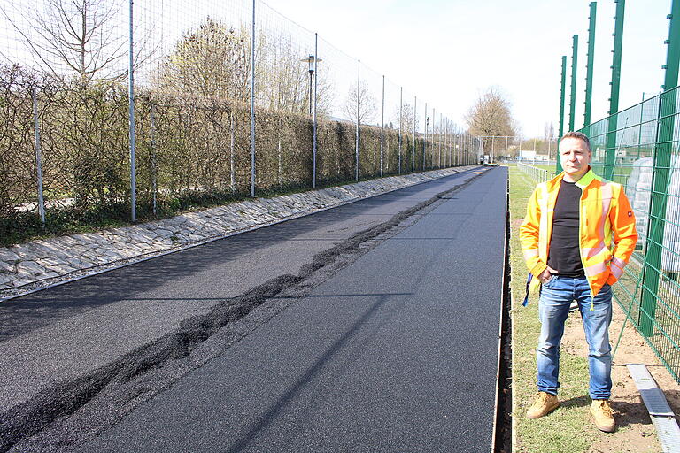 Janusch Lenard vom Städtischen Tiefbauamt an der 100-Meter-Laufbahn. Sie soll Mitte nächster Woche fertiggestellt sein.