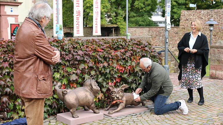 Kritisch beäugt von Roland Schaller (links) bedeckte Michael Schecher einen Vogelschiss auf einer der Mops-Figuren mit einer Mopper-Gesichtsmaske. Die Dritte Bürgermeisterin Ruth Steger amüsierte sich.