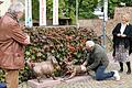 Kritisch beäugt von Roland Schaller (links) bedeckte Michael Schecher einen Vogelschiss auf einer der Mops-Figuren mit einer Mopper-Gesichtsmaske. Die Dritte Bürgermeisterin Ruth Steger amüsierte sich.