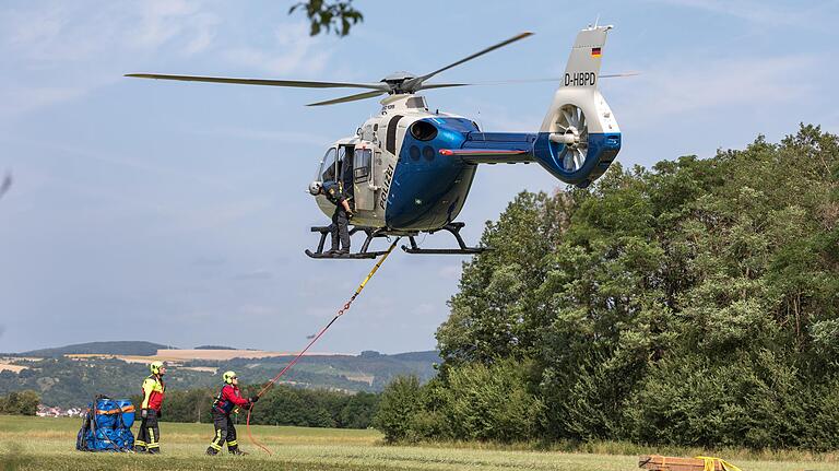 Volle Konzentration beim Befestigen einer Ladung am Helikopter. Flugpersonal und Bodenpersonal kommuniziert nur über Handzeichen.