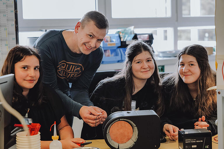 Selina Volkert, Ivana und Ivona Petkovska von der Eduard Mörike Gemeinschaftsschule in Bad Mergentheim arbeiten am leuchtenden und wasserwärmenden Hundenapf. Unterstützt werden sie dabei von ecom-Mitarbeiter Maik Gutte.