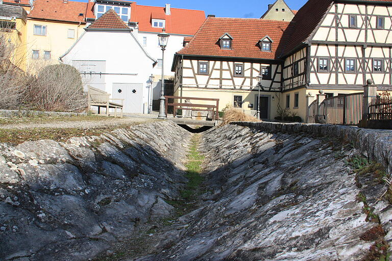 Aus den beschädigten Fugen der Wasserrinne wuchert das Unkraut.