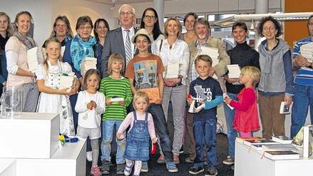 Höchberger Lesefreunden ihre Buchgeschenke überreicht       -  (hig)   Für die Lesefreunde der Bibliothek Markt Höchberg hat sich das Warten gelohnt. Während am Welttag des Buches, der bereits am 23. April gefeiert wurde, noch die Handwerker zugange waren, konnten die 14 Auserwählten eine Woche später nicht nur ihre Buchgeschenke von Bürgermeister Peter Stichler in Empfang nehmen, sondern auch die neu gestaltete Bibliothek bestaunen und auf sich wirken lassen. Die Idee ist so einfach wie genial, mit einem Buchgeschenk jemanden zum Lesen bringen. Ziel war es, über ein persönliches Buchgeschenk und das Teilen von Lesefreude auch diejenigen für das Lesen zu begeistern, die bisher wenig oder gar nicht zum Buch gegriffen haben. Über 3100 Bibliotheken und Buchhandlungen haben sich deutschlandweit als Abholort für die Buchpakete zur Verfügung gestellt. 55 000 Menschen wollten zum Buchschenker werden, 20 000 von Ihnen (per Los ermittelt) erhielten die Möglichkeit, 10 Exemplare eines gewünschten Buches an viele potenzielle Buchfans zu verschenken. Aus den elf Titeln haben sich die Höchberger sieben unterschiedliche Bücher ausgesucht. Spitzenreiter war &bdquo;Schiffbruch mit Tiger&ldquo; des kanadischen Schriftstellers Yann Martel. Aus geteilter Freude kann so doppelte Freude werden, sind auch Bürgermeister Peter Stichler und Martha Maucher, Leiterin der Bibliothek, vom Erfolg der Aktion überzeugt. Gemeinsam haben sie die Buchpakete an die Höchberger Lesefreunde weitergegeben und damit unterstrichen, dass die Freude und an der Lesekultur nicht nur durch die neuen strahlenden Räumlichkeiten, sondern auch durch strahlende Gesichter zum Ausdruck kommen soll.