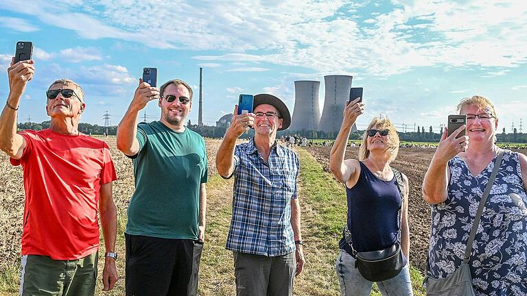 Vor der Sprengung der Kühltürme des Kernkraftwerkes in Grafenrheinfeld knipsen diese Zuschauer mit ihren Handys ein Erinnerungsfoto.