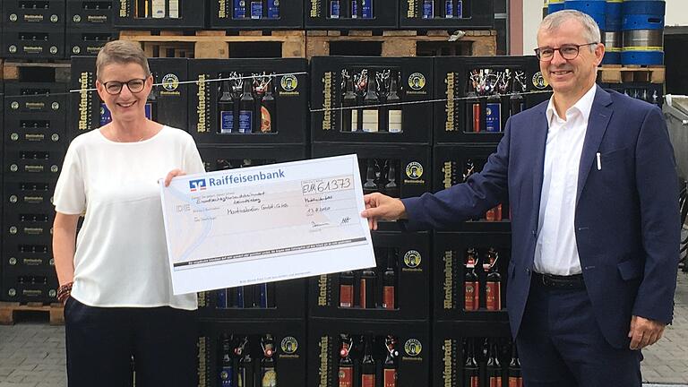 Scheckübergabe nach der Crowfunding-Aktion zu Gunsten der Marktheidenfelder Martinsbräu: (von links) Brauereichefin Maria Martin und Markus Baumann, Regionaldirektor der Raiffeisenbank Marktheidenfeld.