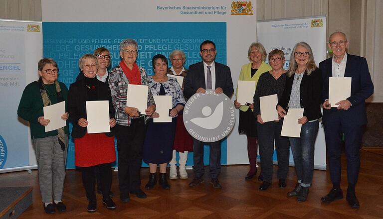 Bayerns Gesundheitsminister Klaus Holetschek (Mitte) hat am Donnerstag in Würzburg die Auszeichnung „Weißer Engel“ an zehn Bürgerinnen und Bürger aus Unterfranken überreicht. Darunter war auch Elisabeth Rost aus Dettelbach (Vierte von links). Bayerns Gesundheitsminister Klaus Holetschek (Mitte) hat am Donnerstag in Würzburg die Auszeichnung „Weißer Engel“ an zehn Bürgerinnen und Bürger aus Unterfranken überreicht. Darunter war auch Elisabeth Rost aus Dettelbach (Vierte von links).