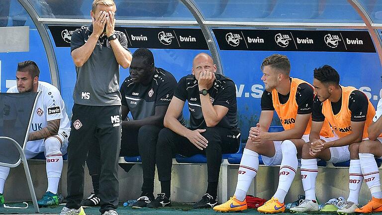 GER, Fussball. 3.Liga, VfL Osnabrueck - Wuerzburger Kickers, 28.7.2018, Stadion an der Bremer Bruecke - Nicht zu fassen! Trainer Michael Schiele schlägt nach dem Osnabrücker 1:2 in der Nachspielzeit die Hände vor dem Gesicht zusammen. Auf der Bank schauen (von links) Dominic Baumann, Co-Trainer Lamine Cisse, Torwarttrainer Robert Wulnikowski, Ibrahim Hajtic und Onur Ünlücifci ziemlich bedröppelt drein. GER, Fussball. 3.Liga, VfL Osnabrueck - Wuerzburger Kickers, 28.7.2018, Stadion an der Bremer Bruecke - Nicht zu fassen! Trainer Michael Schiele schlägt nach dem Osnabrücker 1:2 in der Nachspielzeit die Hände vor dem Gesicht zusammen. Auf der Bank schauen (von links) Dominic Baumann, Co-Trainer Lamine Cisse, Torwarttrainer Robert Wulnikowski, Ibrahim Hajtic und Onur Ünlücifci ziemlich bedröppelt drein.