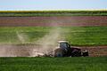 Landwirt bearbeitet Acker       -  Ein Landwirt bewirtschaftet ein Feld mit einem Traktor.