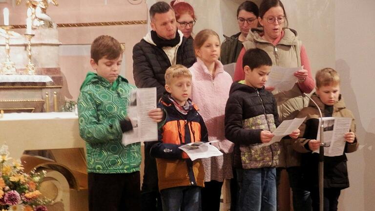 Die Kommunionkinder mit ihren Eltern im Chorraum der St.-Aegidius-Kirche in Gernach: sie stellen sich vor und gestalten den Gottesdienst mit.